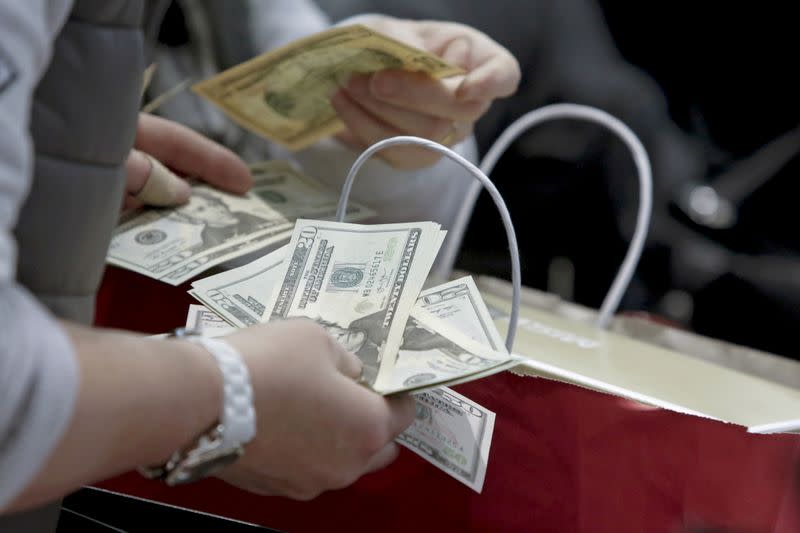 FILE PHOTO: People count money at Macy's Herald Square store during the early opening of the Black Friday sales in the Manhattan borough of New York.