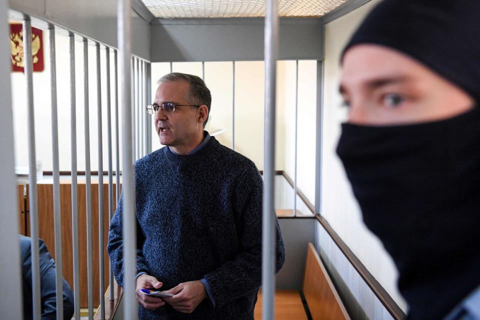 In this photo taken on August 23, 2019, Paul Whelan, left, stands inside a defendants' cage during a hearing at a court in Moscow.