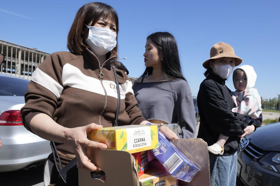 Members of Poland's Vietnamese community collect food donations, in Warsaw, Poland, Wednesday, May 15, 2024. A weekend fire in a shopping center in Warsaw dealt tragedy to many members of Poland's Vietnamese community. People lost entire livelihoods and say they don't know how they will manage to make a living. (AP Photo/Czarek Sokolowski)