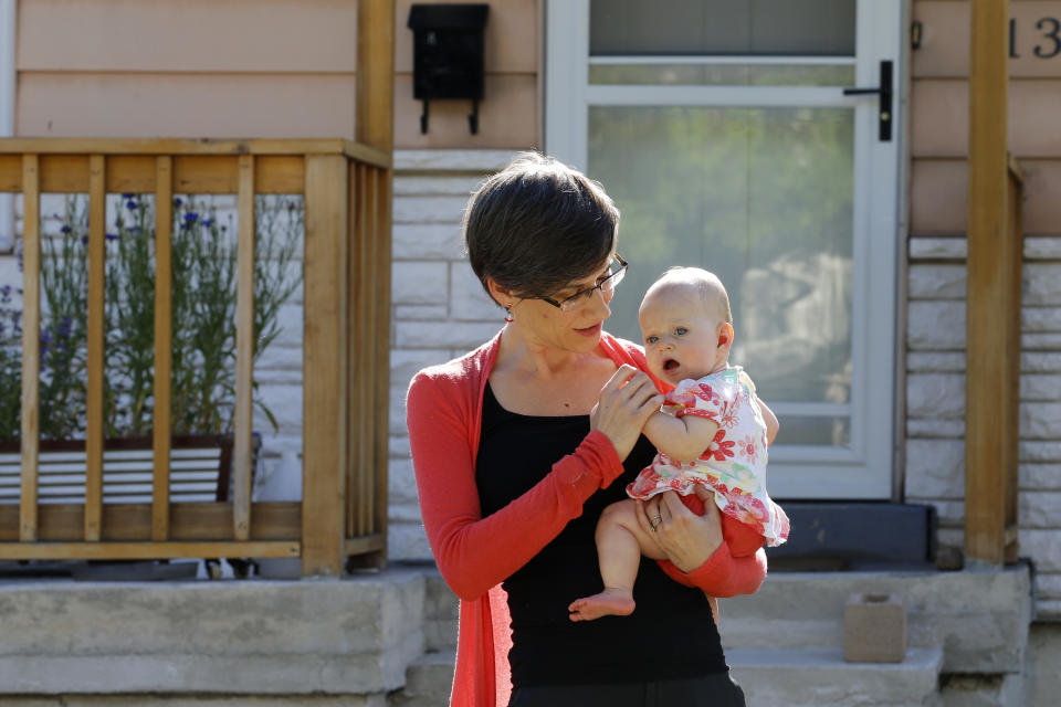 In this Friday, May 29, 2020, photo, Sara Adelman holds her daughter Amelia in Salt Lake City. Adelman is burning through her vacation time to help manage her current status as a working-from-home mom since her daughter's daycare closed due to the coronavirus pandemic. (AP Photo/Rick Bowmer)