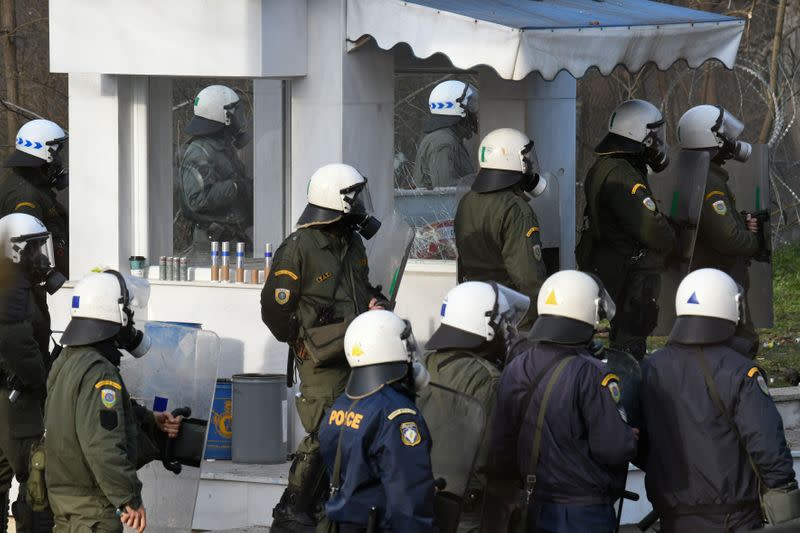 Greek riot police stand guard during clashes with migrants who want to cross into Greece from Turkey's Pazarkule border crossing, in Kastanies