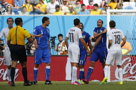 Italy's Giorgio Chiellini (2nd R) complains to referee Marco Rodriguez of Mexico (2nd L) during their 2014 World Cup Group D soccer match against Uruguay at the Dunas arena in Natal June 24, 2014. Chiellini claimed that Uruguay's Luis Suarez bit him on his shoulder during a challenge. REUTERS/Yves Herman