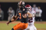 Oklahoma safety Delarrin Turner-Yell (32) wraps up Oklahoma State quarterback Spencer Sanders (3) during the first half of an NCAA college football game Saturday, Nov. 27, 2021, in Stillwater, Okla. (AP Photo/Sue Ogrocki)