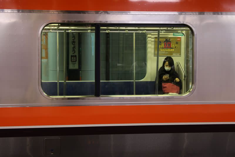 Woman wearing a protective face mask, following an outbreak of the coronavirus, is seen inside a train at the Tokyo station