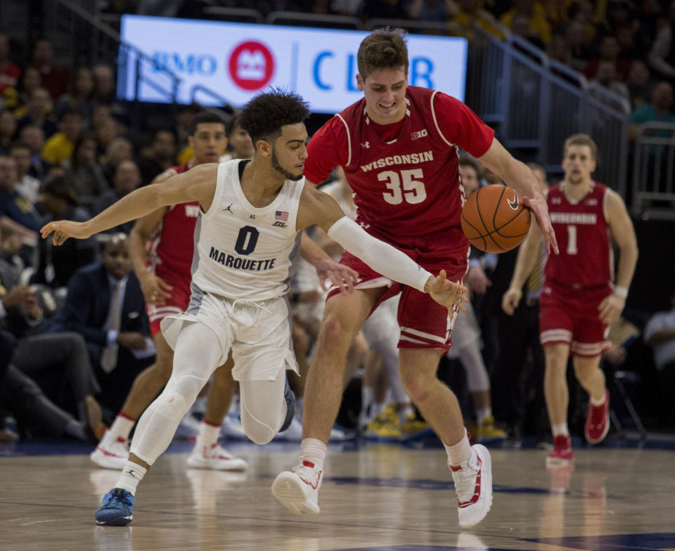 Marquette guard Markus Howard, left, tries to grab the loose ball from Wisconsin forward Nate Reuvers, right, during the first half of an NCAA college basketball game Saturday, Dec. 8, 2018, in Milwaukee. (AP Photo/Darren Hauck)