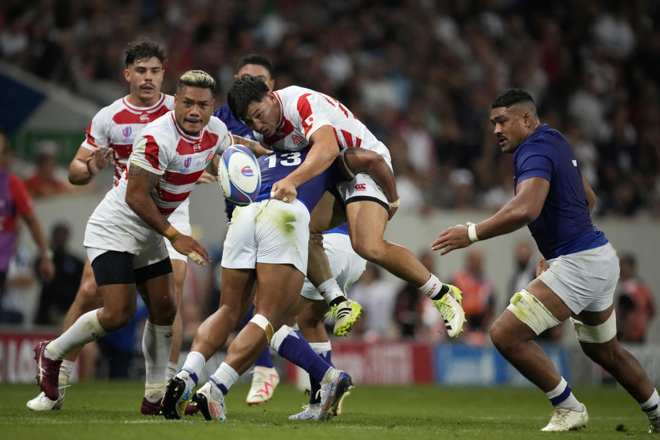 Japan's Ryoto Nakamura, top, is tackled by Samoa's Tumua Manu during the Rugby World Cup Pool D match between Japan and Samoa, at the Stadium de Toulouse in Toulouse, France, Thursday, Sept. 28, 2023. (AP Photo/Christophe Ena)