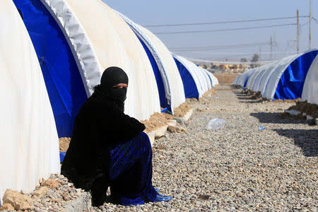 A displaced Iraqi woman, who fled a village controlled by Islamic State militants, rests outside her tent at the refugee camp in Hammam Ali, south of Mosul, Iraq February 24, 2017. REUTERS/Alaa Al-Marjani