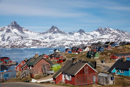 FILE PHOTO: Snow covered mountains rise above the harbour and town of Tasiilaq