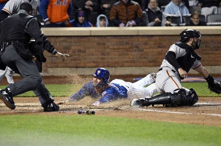 New York Mets' Pete Alonso scores on a double by Eduardo Escobar as San Francisco Giants catcher Curt Casali, right, takes the throw during the third inning of the second game of a baseball double-header Tuesday, April 19, 2022, in New York. (AP Photo/Bill Kostroun)