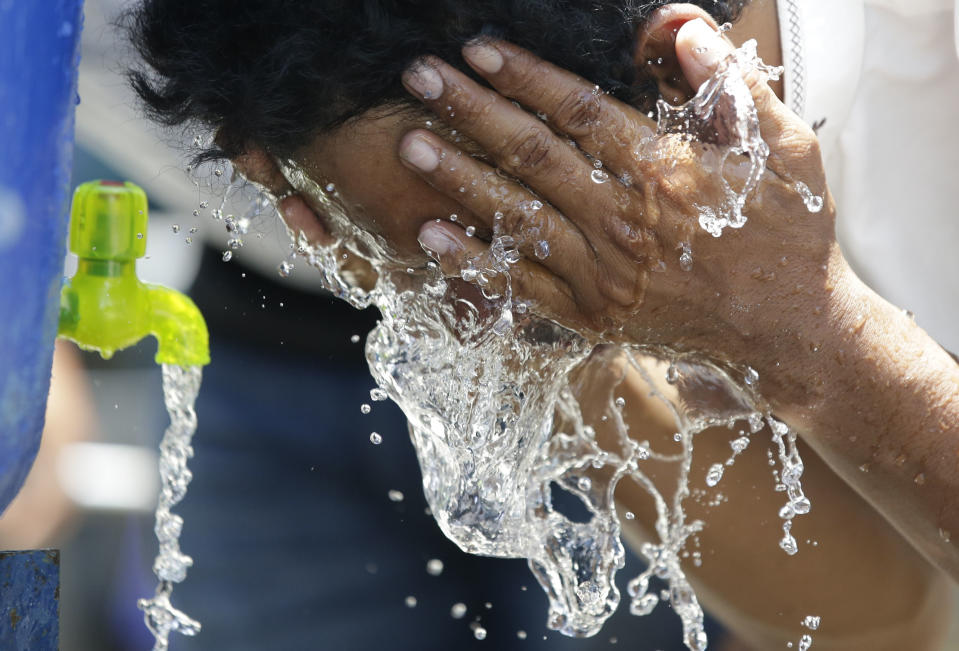 In this Friday, Oct. 5, 2018, file photo, a man cleans himself before attending Friday prayers outside a damaged mosque caused by the massive earthquake and tsunami in Palu, Central Sulawesi, Indonesia. (AP Photo/Aaron Favila, File)