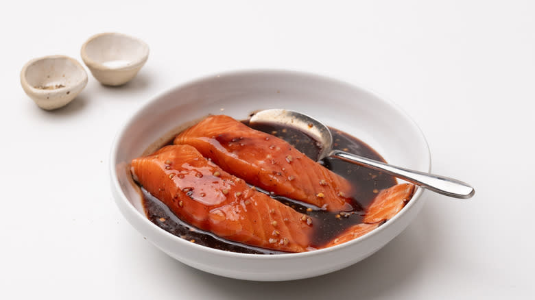 glazed salmon in a bowl with metal spoon