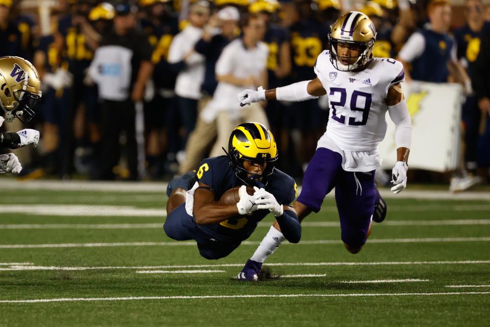 Michigan's Cornelius Johnson runs with the ball in the first half against Washington at Michigan Stadium.