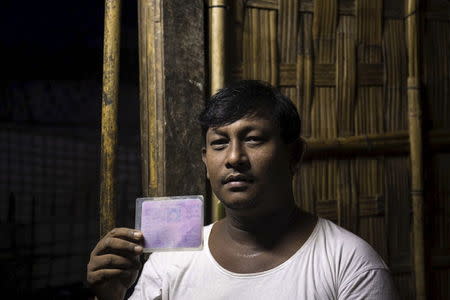 Shwe Oo, 36, a Rohingya Muslim who will vote on Sunday, shows his citizen card in a refugee camp outside Sitttwe, Rakhine state November 7, 2015. REUTERS/Sai Aung Min