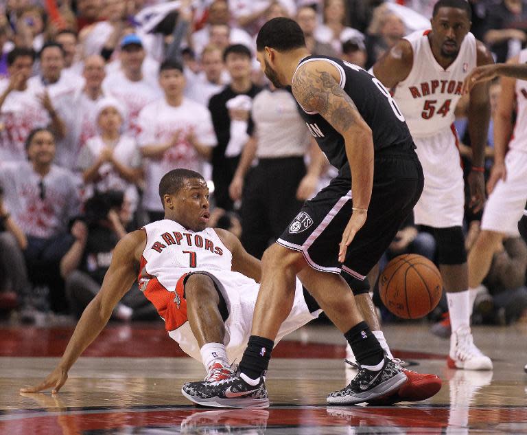 Deron Williams of the Brooklyn Nets knocks Kyle Lowry of the Toronto Raptors to the floor in Game One of the NBA Eastern Conference play-off at the Air Canada Centre on April 19, 2014 in Toronto, Ontario, Canada which the Nets won 94-87