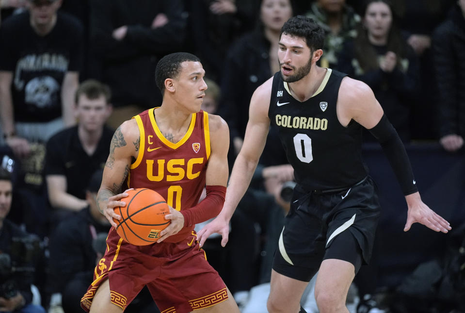 Southern California guard Kobe Johnson, left, looks to pass the ball as Colorado guard Luke O'Brien defends during the second half of an NCAA college basketball game Saturday, Jan. 13, 2024, in Boulder, Colo. (AP Photo/David Zalubowski)