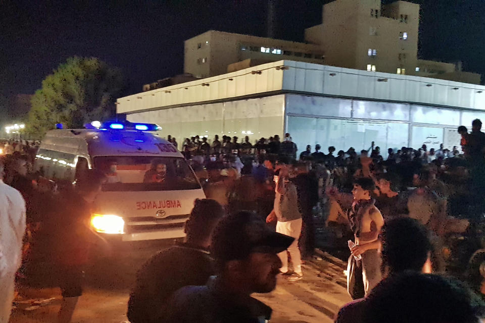 People gather outside a COVID-19 hospital in Nasiriyah, Iraq, early Tuesday, July 13, 2021. A catastrophic blaze erupted at the coronavirus hospital ward. It was the second time a large fire killed coronavirus patients in an Iraqi hospital this year. (AP Photo/Str)