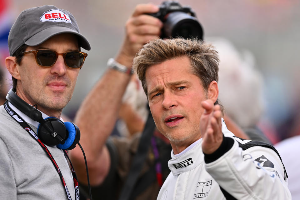 NORTHAMPTON, ENGLAND - JULY 09: Brad Pitt, star of the upcoming Formula One based movie, Apex, and Joseph Kosinski, director of the upcoming Formula One based movie, Apex, talk on the grid during the F1 Grand Prix of Great Britain at Silverstone Circuit on July 09, 2023 in Northampton, England. (Photo by Dan Mullan/Getty Images)