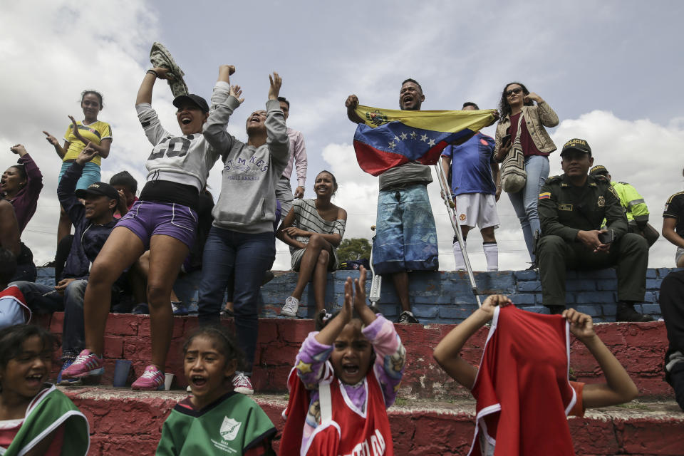 Venezuelan migrants celebrate a goal during a soccer match at their temporary camp in Bogota, Colombia, Wednesday, Nov. 21, 2018. City officials organized soccer matches for migrants living in the camp, built by the city's social welfare agency to accommodate migrants who had previously been living in tents made of plastic sheets and scrap materials outside the city's bus terminal. (AP Photo/Ivan Valencia)