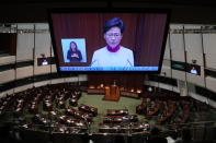 A TV screen shows Hong Kong Chief Executive Carrie Lam delivering her policies at the chamber of Legislative Council in Hong Kong, Wednesday, Oct. 6, 2021. Lam announced a major development plan Wednesday for Hong Kong's border area with mainland China in the last annual policy address of her current term. (AP Photo/Kin Cheung)