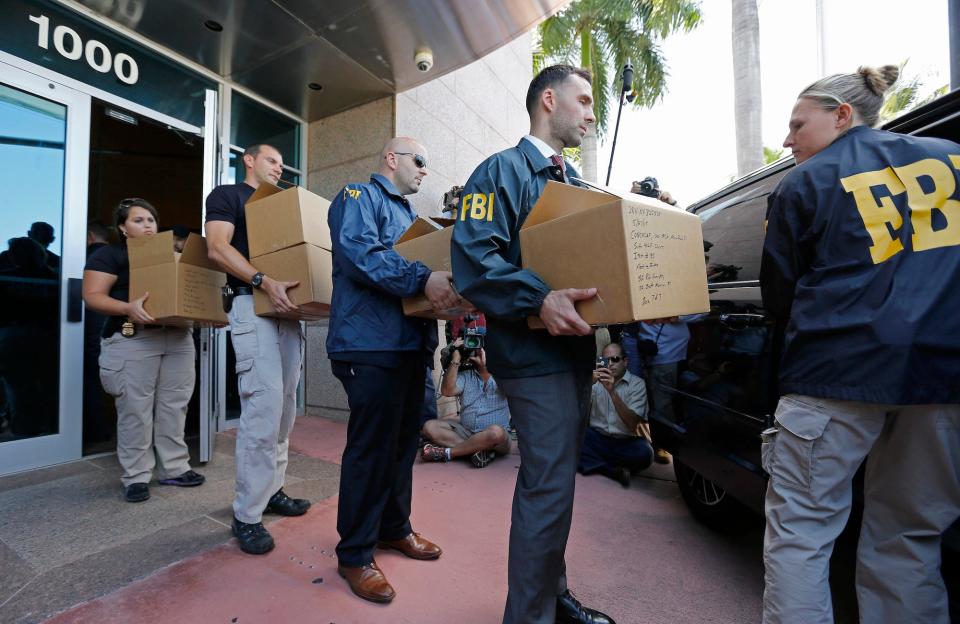 FBI agents carry boxes from the headquarters of CONCACAF after it was raided on May 27, 2015 in Miami Beach, Florida. The raid is part of an international investigation of FIFA where nine FIFA officials and five corporate executives were charged with racketeering, wire fraud and money laundering conspiracies