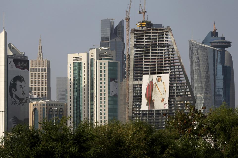 FILE - The images of the Emir of Qatar, Sheikh Tamim bin Hamad Al Thani hang on the towers in Doha, Qatar, May 5, 2018. Qatar will be on the world stage like it never has before as the small, energy-rich nations hosts the 2022 FIFA World Cup beginning this November. (AP Photo/Kamran Jebreili, File)