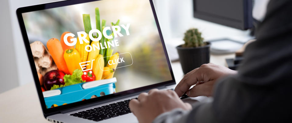 A man orders groceries on his laptop.