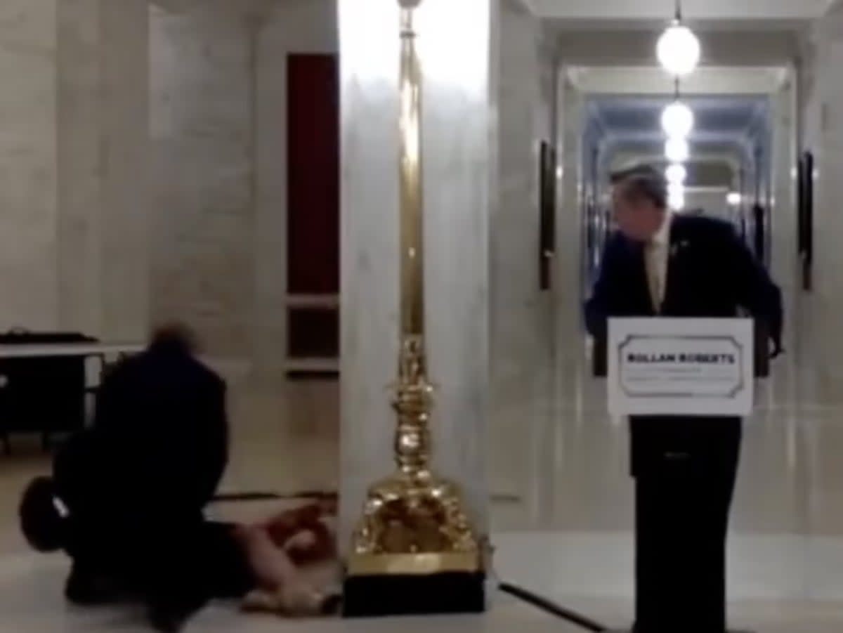 Rollin Roberts looks on as his wife collapses at his presidential campaign announcement (Twitter/@RonFilipkowski)