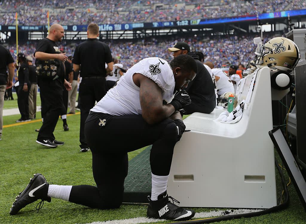 Saints defensive tackle Nick Fairley kneels on the sideline during a game against the Giants. (Getty Images)