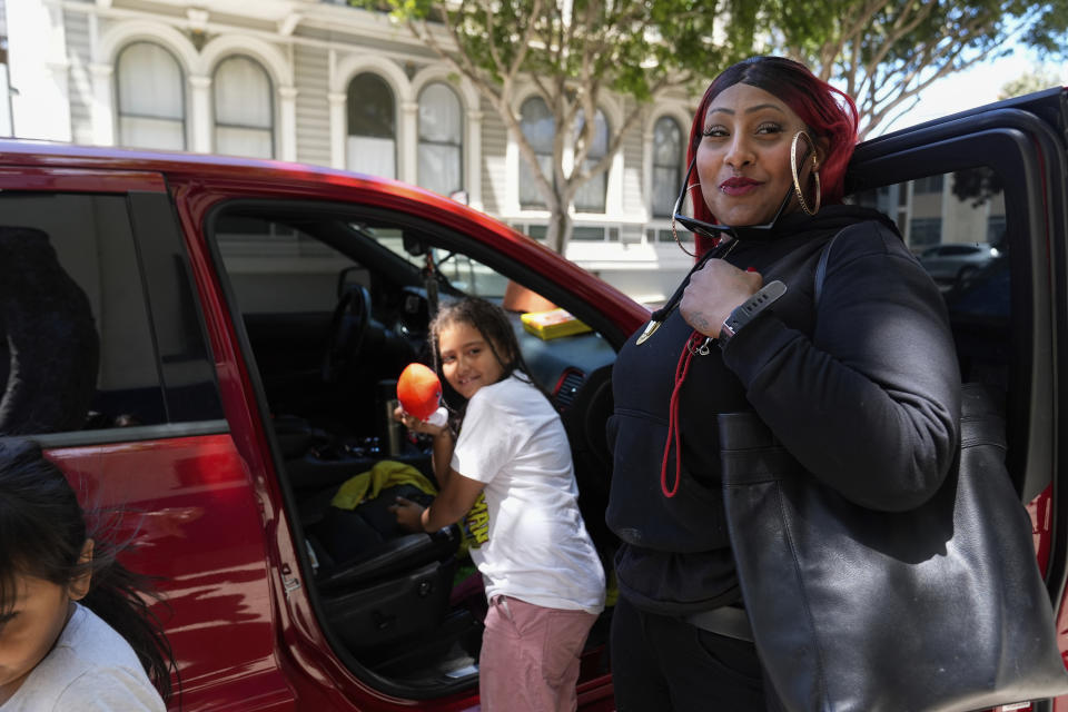 Teniah Tercero, right, gets her three daughters into her SUV on Thursday, May 23, 2024, in San Francisco. Tercero and her daughters have lived in many different places, from motel rooms to her car. (AP Photo/Godofredo A. Vásquez)