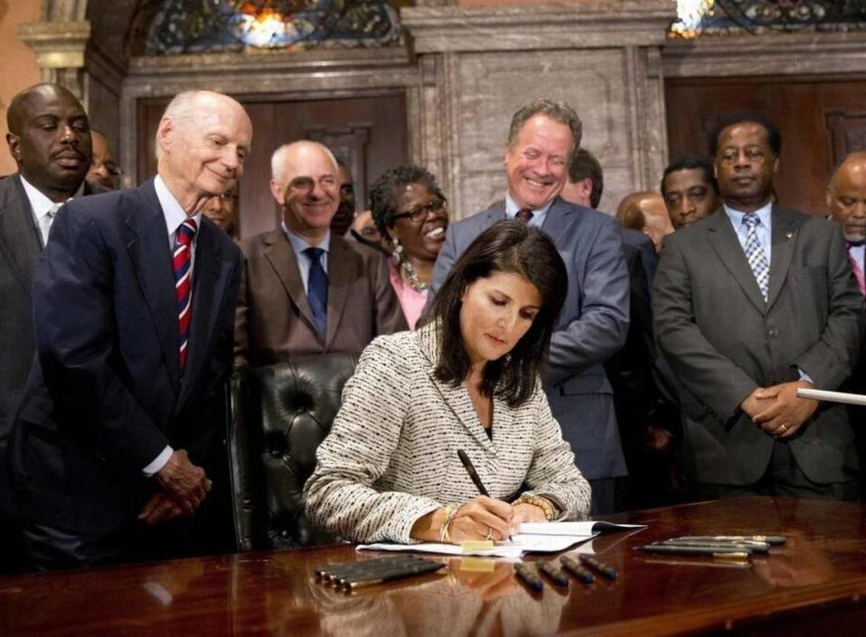Then-South Carolina Gov. Nikki Haley signs a bill into law as former South Carolina governors and officials look in July 2015 at the Statehouse in Columbia, S.C. The law enabled removal of the Confederate flag from the Statehouse grounds.