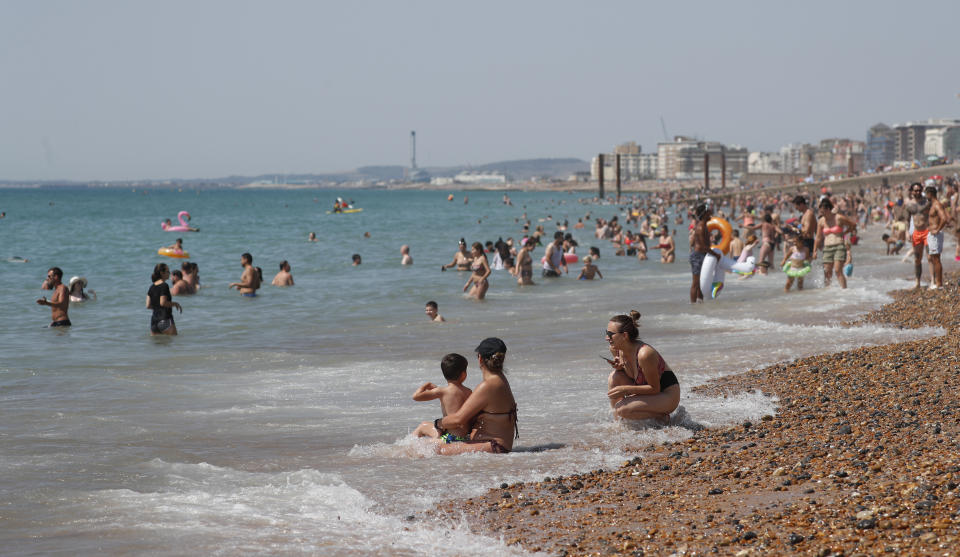 Beachgoers enjoy the sunshine and sea on what is now Britain's hottest day of the year so far, in Brighton, England, Friday, July 31, 2020. Temperatures have reached 35C (95F) at London's Heathrow Airport. (AP Photo/Alastair Grant)