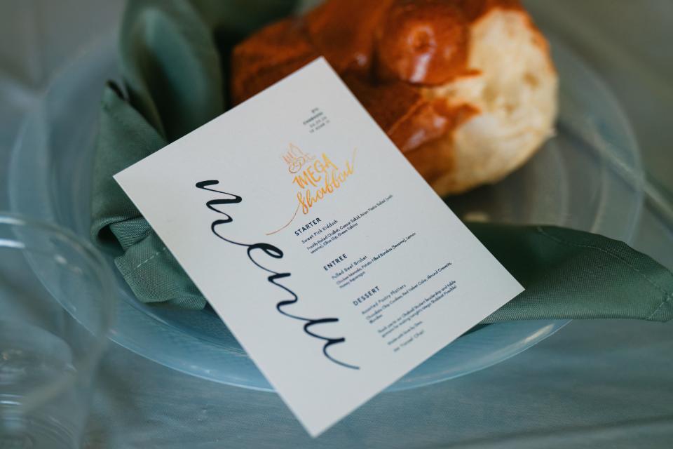 A menu card with the offered dishes of the night lies on the table at Mega Shabbat hosted by Chabad IU on March 29, 2024.