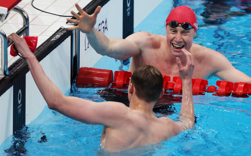 Tom Dean of Team Great Britain shakes hands with Duncan Scott of Team Great Britain after winning the gold medal in the Men's 200m Freestyle Final on day four of the Tokyo 2020 Olympic Games at Tokyo Aquatics Centre on July 27, 2021 in Tokyo, Japan. - GETTY IMAGES