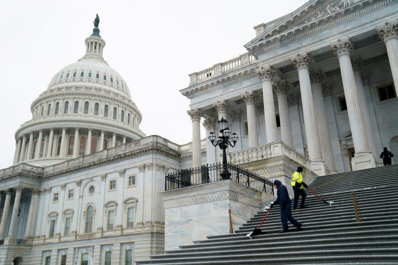 FILE PHOTO: Workers shovel snow from the steps of the U.S. Capitol in Washington