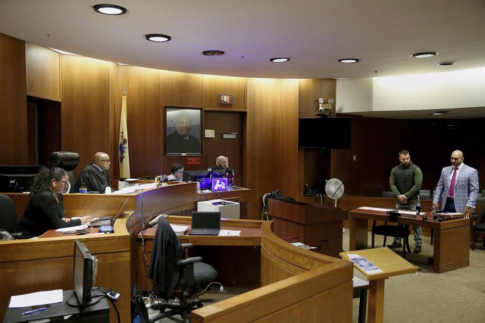 Mark D'Amico, second from right, stands with his lawyer, Mark Davis, right, as he pleads guilty to one count of misappropriating entrusted funds in Judge Terrence Cook's courtroom at Burlington County Superior Court in Mount Holly, N.J., on Friday, Dec. 6, 2019. Along with his then-girlfriend, Kate McClure, and a homeless man, Johnny Bobbitt, D'Amico allegedly set up a false online fundraiser and kept the money for themselves. (Tim Tai/The Philadelphia Inquirer via AP)