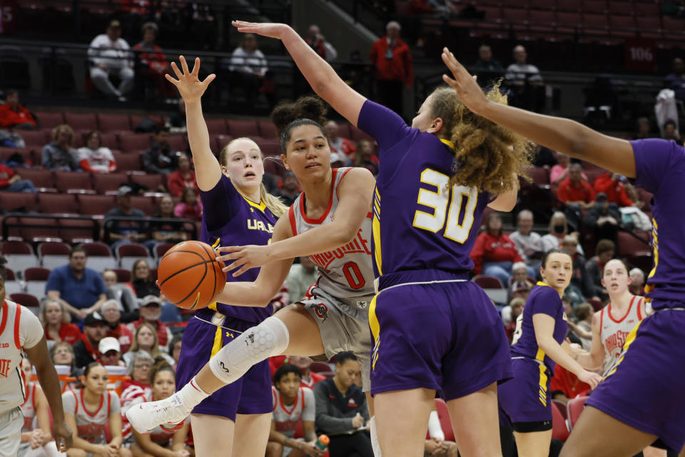 Ohio State's Madison Greene, center, passes the ball between Albany's Freja Werth, left, and Karyn Sanford during the second half of an NCAA college basketball game on Friday, Dec. 16, 2022, in Columbus, Ohio. (AP Photo/Jay LaPrete)