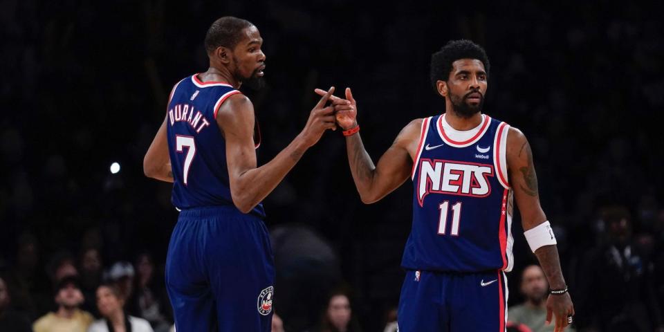 Kevin Durant and Kyrie Irving high-five during a Nets game in 2022.