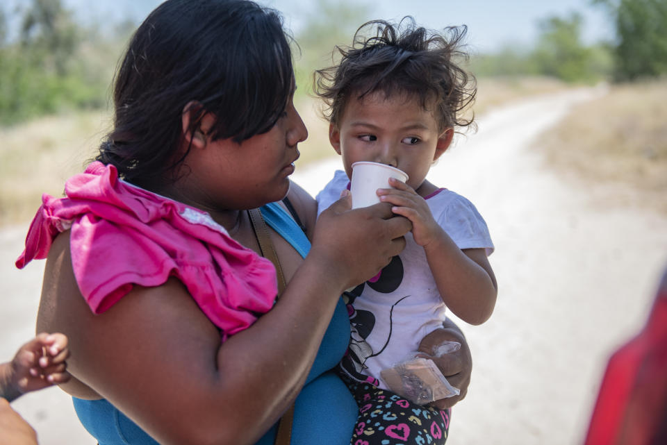 An illegal immigrant gives her daughter water 