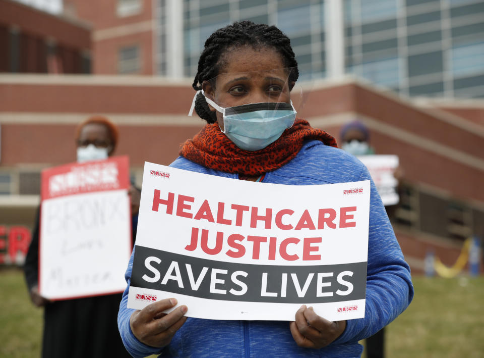 Rehabilitation nurse Edith Ihejirika holds a sign as she participates in a demonstration outside the emergency entrance to Jacobi Medical Center in the Bronx borough of New York, Saturday, March 28, 2020. Nurses at the hospital demonstrated demanding adequate Personal Protective Equipment after Mount Sinai West emergency room nurse Kious Kelly, died Tuesday, after a 10-day bout with the disease. New York has the most cases of the virus in the world, according to the World Health Organization. (AP Photo/Kathy Willens)