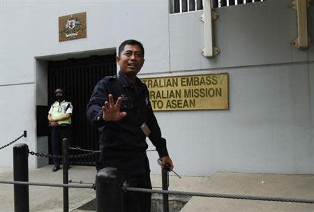 A security personnel raises his hand in an attempt to stop the media from taking pictures in front of the Australian Embassy gate in Jakarta November 1, 2013. REUTERS/Beawiharta