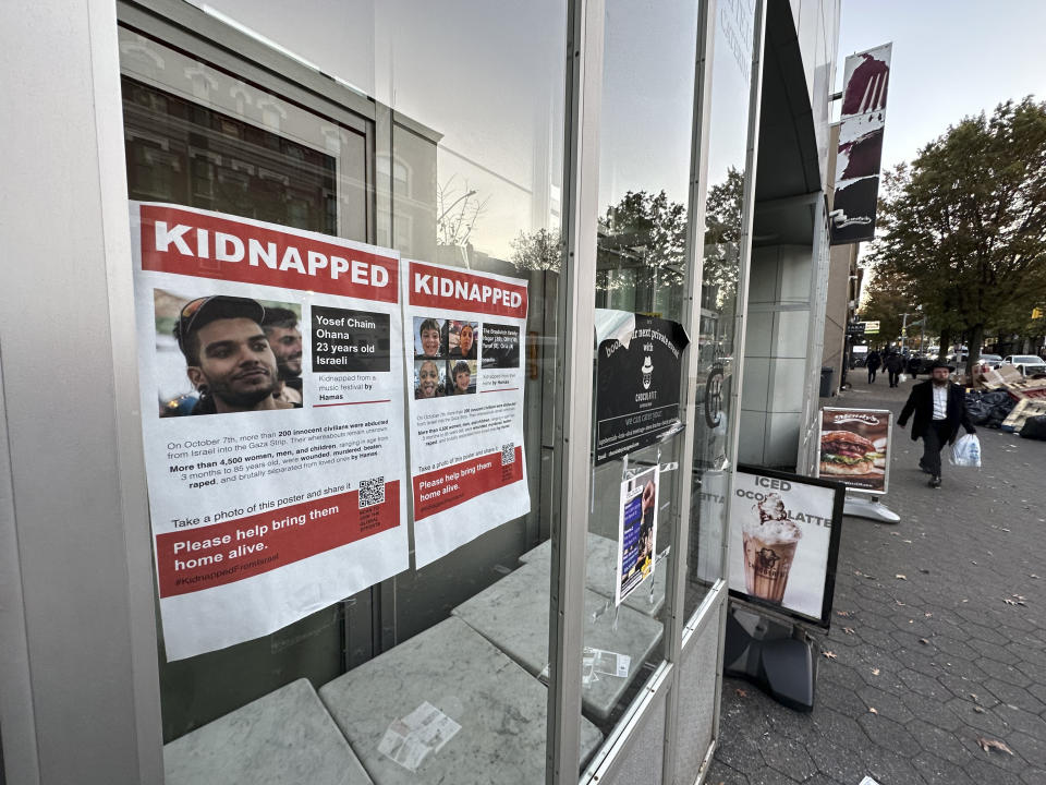 Posters of Israeli hostages being held by Hamas after its attack on Israel last month, is posted on a window of the Jewish Children's Museum, Friday, Nov. 3, 2023, in Brooklyn, New York. While posters of hostages were created to raise awareness and support, they've also angered others who are critical of Israel's actions and history in the conflict with Palestinians. (AP Photo/Bebeto Matthews)