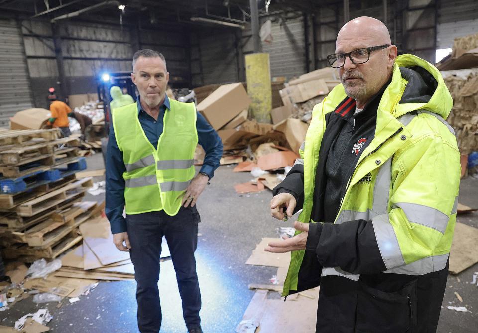 Brian Slesnick, president of the S. Slesnick Co., right, along with David Held, executive director Stark-Tuscarawas-Wayne Joint Solid Waste District, talk about what goes into gathering and bailing cardboard before it is sent off to a mill and recycled into paper in this file photo.