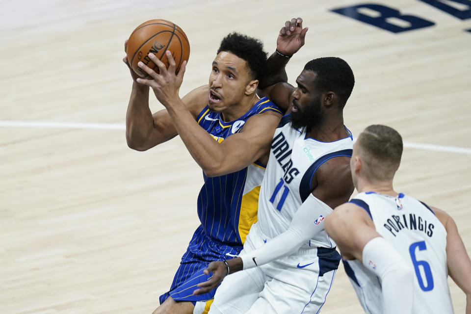 Indiana Pacers' Malcolm Brogdon (7) goes to the basket against Dallas Mavericks' Tim Hardaway Jr. (11) during the first half of an NBA basketball game, Wednesday, Jan. 20, 2021, in Indianapolis. (AP Photo/Darron Cummings)