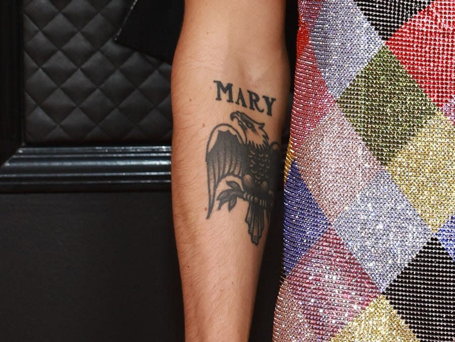 Tattoos of the name Mary and an eagle on Harry Styles' right arm.