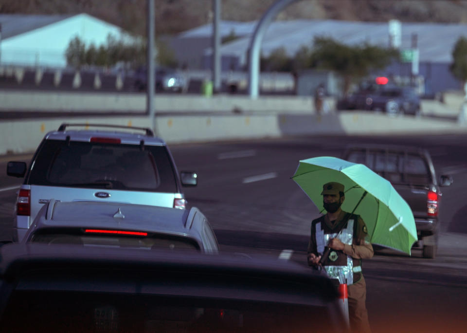 A Saudi traffic policeman raises his umbrella at a check point in the Arafat tent camp, in the Saudi Arabia's holy city of Mecca, Tuesday, July 5, 2022. Saudi Arabia is expected to receive one million Muslims to attend Hajj pilgrimage, which will begin on July 7, after two years of limiting the numbers because coronavirus pandemic. (AP Photo/Amr Nabil)