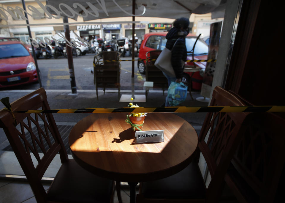 FILE - In this March 15, 2021, file photo, plastic tape prevents people from sitting at a coffee table in downtown Rome. Optimism is spreading in the U.S. as COVID-19 deaths plummet and states ease restrictions and open vaccinations to younger adults. But across Europe, dread is setting in with another wave of infections that is closing schools and cafes and bringing new lockdowns. (AP Photo/Alessandra Tarantino, File)