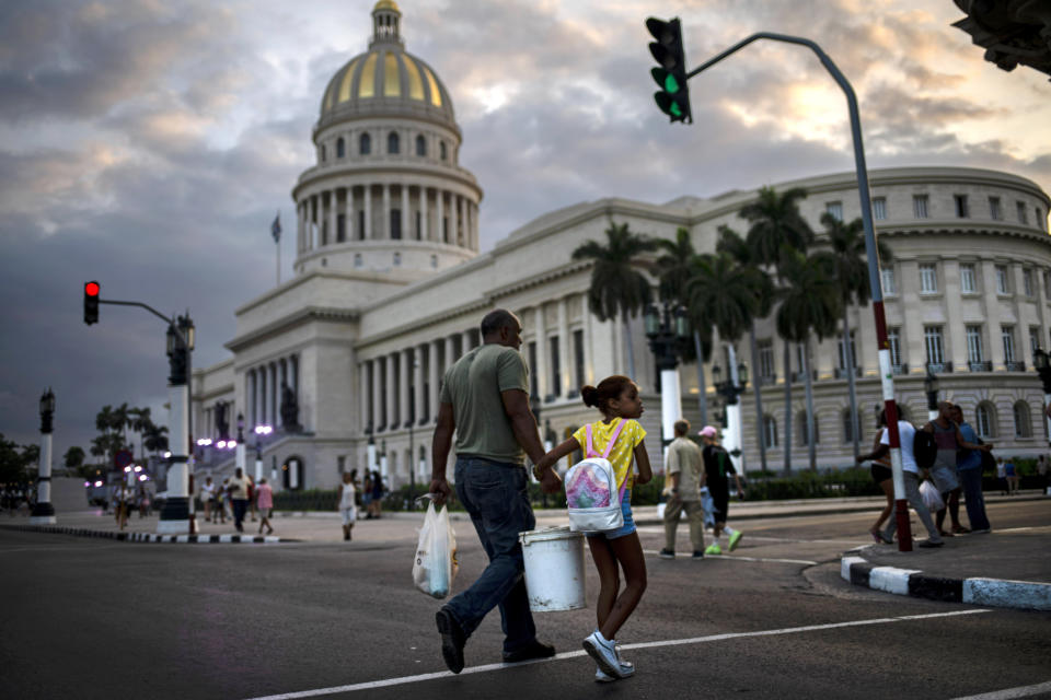 In this Nov 8, 2019 photo, people walk next to the Capital building, with its dome recently restored by Russian specialists in Havana, Cuba. The city will celebrate its 500th anniversary on Nov. 16. (AP Photo/Ramon Espinosa)