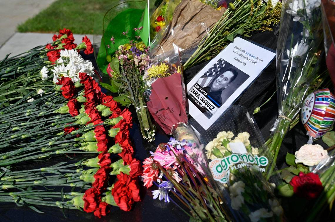 One day after North Kansas City Police officer Daniel Vasquez was fatally shot, people paid tribute to the fallen officer whose police vehicle was laden with flowers on Wednesday, July 20, 2022, outside the North Kansas City Police Department.