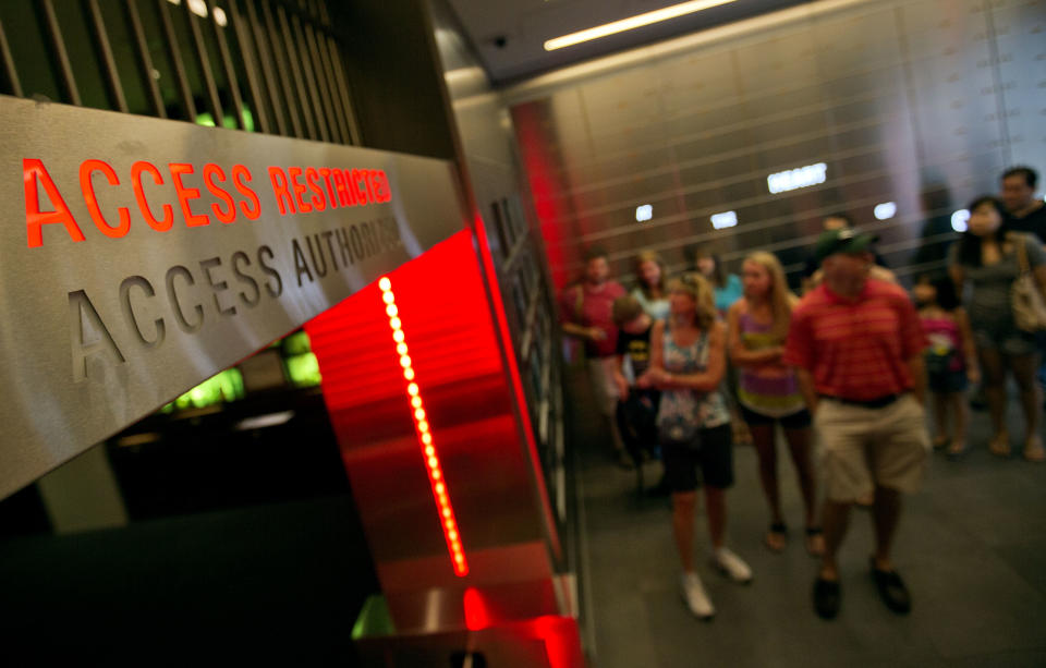 In this Friday, Aug. 9, 2013 photo, a tour group enters the vault exhibit containing the “secret recipe” for Coca-Cola at the World of Coca-Cola museum, in Atlanta. The 127-year-old recipe for Coke sits inside an imposing steel vault that’s bathed in red security lights, while security cameras monitor the area to make sure the fizzy formula stays a secret. (AP Photo/David Goldman)