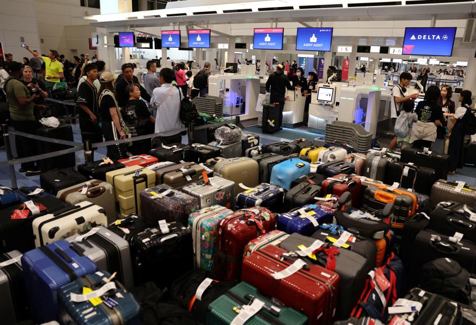 Passengers stands in a line at Delta Airlines’ counter following a global IT outage, at Haneda International Airport in Tokyo, Japan July 19, 2024. REUTERS/Kim Kyung-Hoon